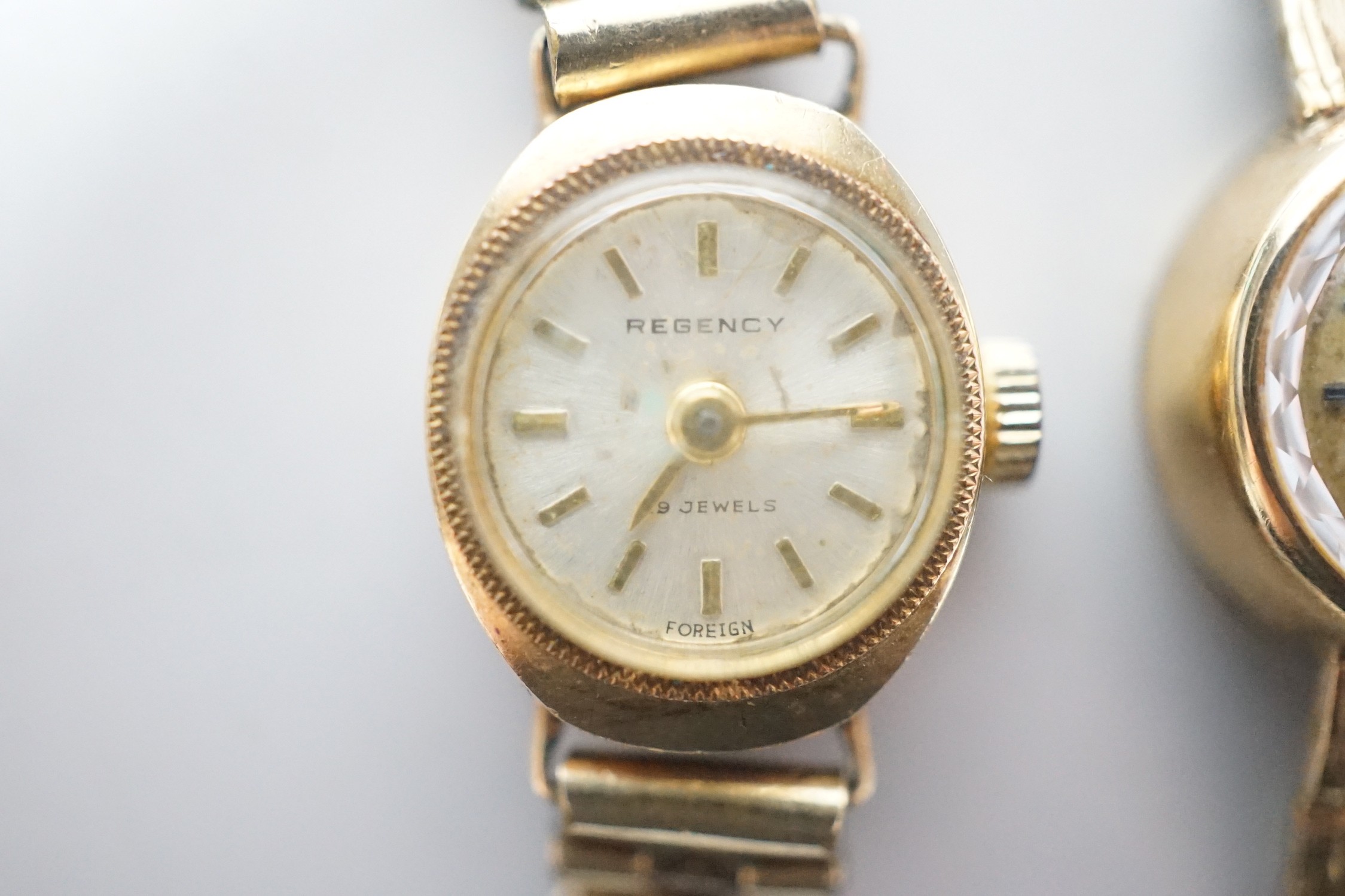 A lady's 9ct gold Omega manual wind wrist watch, on associated 9ct gold bracelet, overall 15.8cm, gross weight 17.8 grams and one other lady's 9ct gold watch on a gold plated bracelet.